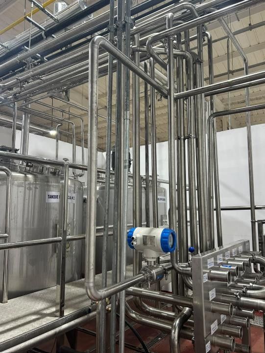 Red de tuberías sanitarias de acero inoxidable con válvulas e instrumentos en una sala de proceso